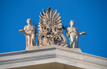 Greek statues from a building at Athens Greece against a blue skyの写真素材