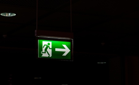 Exit sign post on a black backgroundの写真素材