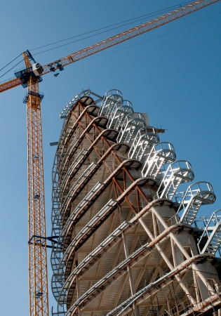 New Skyscraper construction with yellow crane on a clear sky day の写真素材