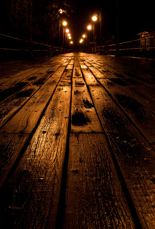 Wooden empty pier illuminated at nightの写真素材