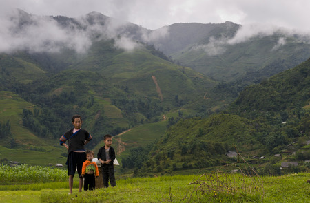Sapa, Vietnam - 11 August:  Traditional Vietnamese family with a man and two boys dressed with traditional clothing and  standing in the rice fields  of Sapa on August 11 2010 in Sapa, Vietnam, Asia.のeditorial素材