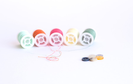 Colorful sewing thread reels and  fashion buttons isolated on a white backgroundの写真素材