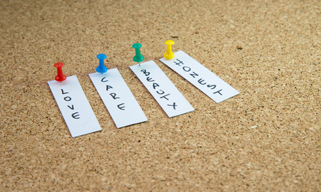 Words of love care, beauty and Honest hanging on a cork board with push pins