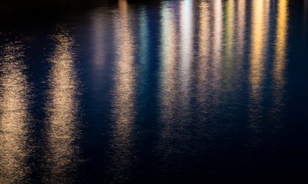 Various colored  city lights on the water creating a beautiful colorful backgroundの写真素材