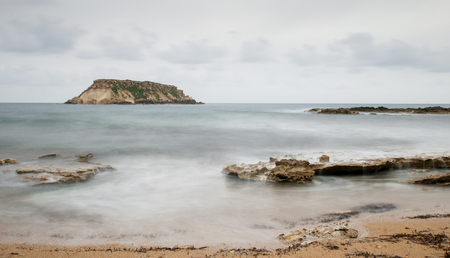 Rocky Seascape with the  small  island of geronisos st.  georges cape at  Paphos city in Cyprusの写真素材