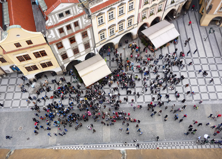 Tourists  at  the picturesque old town Square of Prague waiting for the  astronomical clock to alarm the change of the hour.の写真素材