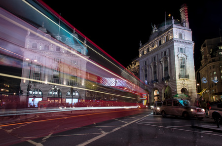 Night scene from the famous London Piccadilly circus square  at the center of London with cars and buses leaving colorful light traces.のeditorial素材