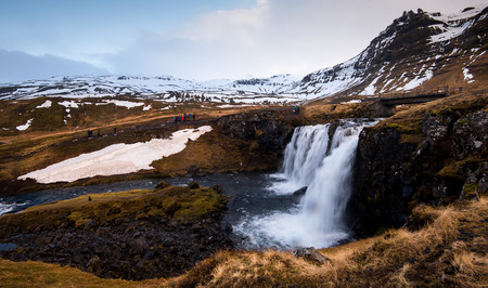 Kirkjufellsfoss, Iceland - March 20 2016: Kirkjufellsfoss  waterfalls with the Kirkjufell mountain and tourist people around , at Grundarfjordur, on the Snaefellsnes peninsula in Iceland.のeditorial素材
