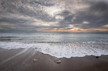 Pebbles on the beach and flowing sea water during sunset creating nice textures. Long exposure...