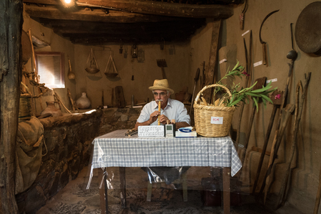 Nicosia, Cyprus - October 9 2016: Senior  man  crafting and playing a handmade Cyprus tradition al music instrument called fogera.のeditorial素材