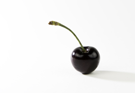 Fresh delicious dark juicy  red cherry fruits   isolated on a white backgroundの写真素材