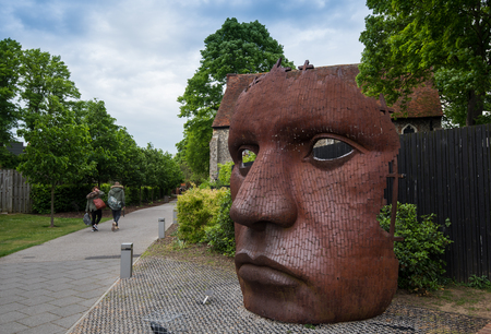 Canterbury, Kent, England - May 15 2017:  The face Mask or Bulkhead art created by Rick Kirby , British sculptor sitting outside Marlowe Theatre at the city of Canterbury, Kent UK.のeditorial素材