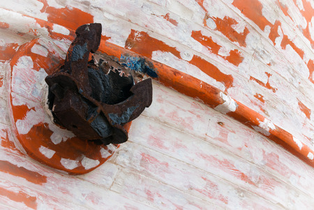 Rusty black anchor on a wooden boat wreck.の写真素材