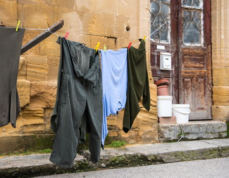 Adult man clothing hanging on a rope outside a house for drying.の写真素材