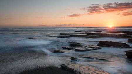 Dramatic beautiful sunset on a rocky coast at Akrotiri area in Limassol, Cyprus. Long exposure...