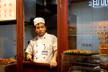 Beijing, China â June 1 2018: Chef in his white uniform cooking traditional Chinese  food on Snack street food market at Beijing in Chinaのeditorial素材