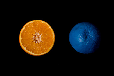 Slices of  blue and orange fresh Citrus orange fruit on a black background. Still-life creative photographの写真素材