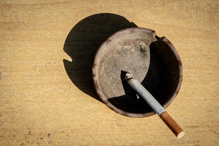 Metal ash tray and burning unhealthy cigarette.の写真素材
