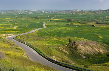 Green Valley with empty road crossing on the countryside of Cyprus in spring.の写真素材