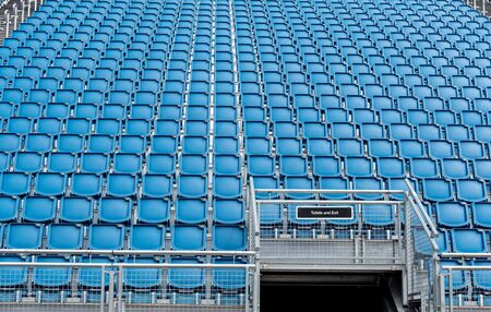 Blue plastic empty stadium or stage chairs in a rowの写真素材