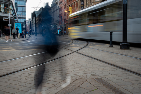 Manchester, United Kingdom - July 15 2019: Unrecognizable people on the move in  the streets on Manchester in United Kingdom and moving trains. Motion blur and long exposure photographyのeditorial素材