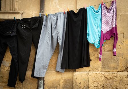 Laundry hanging on a rope and drying outdoor in the clean air saving the environment.