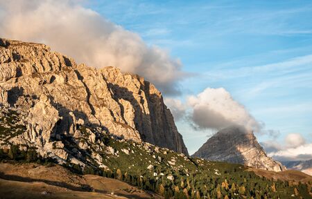 Breathtaking views of the mountain peaks and the clouds covering the peaks in the famous dolomites during sunrise in South Tyrol, Italyの写真素材