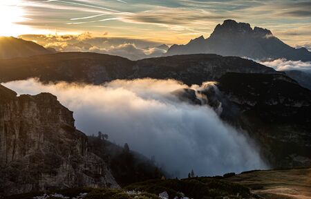 Mountain landscape with fog, late in the evening of the picturesque Dolomites at Tre Cime hiking path area in South Tyrol in Italy.の写真素材