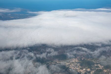 Cumulus dramatic stormy clouds and landscape near Barcelona Spain from an airplane windowの写真素材