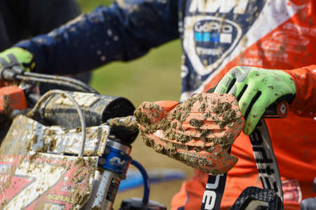 Nicosia, Cyprus, January 13 2019: Athlete on a motorbike and covered with mud during a motocross athletic eventのeditorial素材