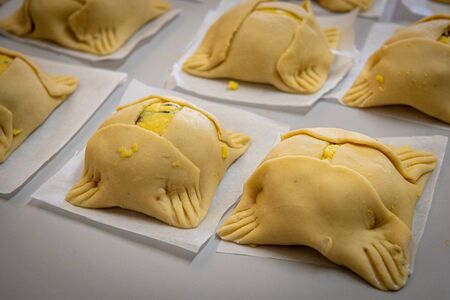 Traditional raw cypriot easter cheese pastries called flaounes in a table ready to be cooked in the clay oven.の写真素材