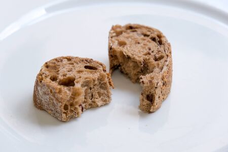 Slices of healthy and nutricious brown bread on a white plate