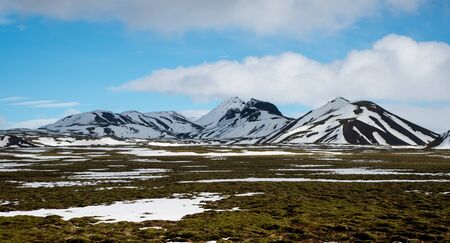 Typical Icelandic dramatic landscape with frozen lake and mountains covered in snow in Iceland,...