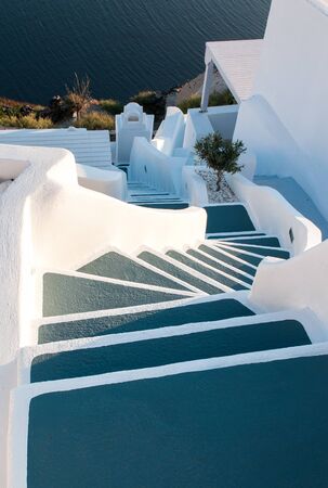 Traditional narrow stair street leading to the sea in Oia village, in Santorini Island, Greece.