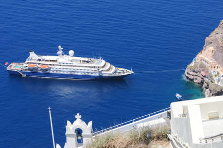 Tourist luxury cruise ship moored at the port of fira city Santorini Greek island Greece in the aegean seaの写真素材