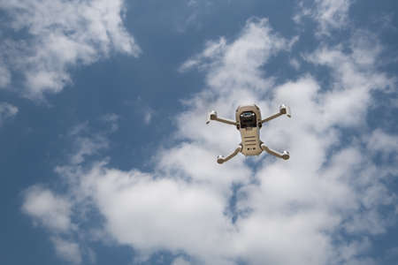 Drone with camera flying over the blue cloudy sky. Aerial landscape photography.の写真素材