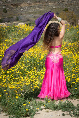 Woman performing belly oriental dancing wearing coloured costume. Dancing outdoorsの写真素材