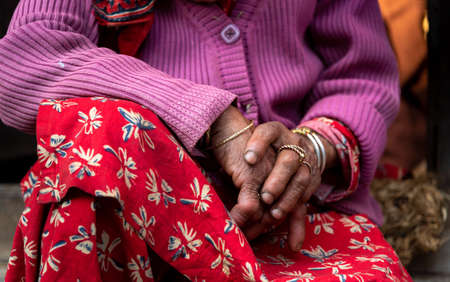 Close up of the crossed wrinkle hands of an elder grandmother nepalese woman.の写真素材