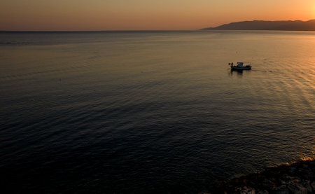Aerial drone view of fishing boat sailing in the sea at sunrise. Latsi Paphos Cyprusの写真素材