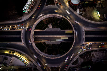 Aerial drone top view of a modern motorway junction roundabout with cars moving. Transportation...