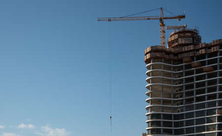 Residential office building construction site and cranes during a vibrant summer day with blue sky.の写真素材