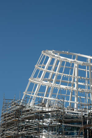 Residential office building construction site and cranes during a vibrant summer day with blue sky.の写真素材