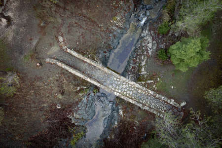 Aerial drone scenic of a medieval stoned bridge with water flowing in the river. Elia Bridge Troodos...