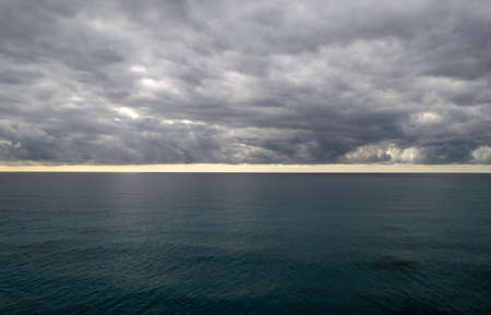 Stormy clouds with dramatic sky above the sea at sunsetの写真素材