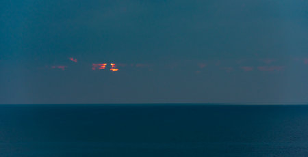 Sunrise in the sea with cloud stormy clouds and orange colour. Seascape in the morning. Sun behind...