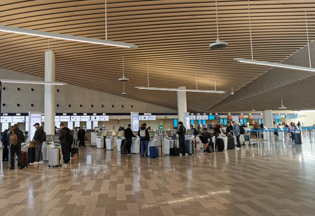 Travellers check-in luggage on departure terminal gate in an International airport.