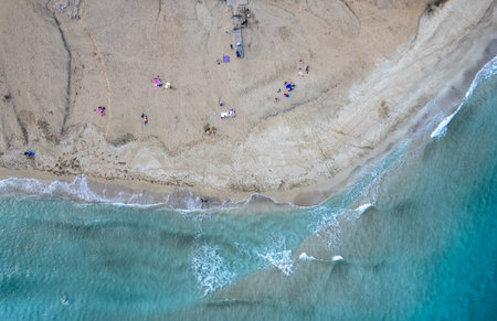 Drone aerial of people resting in a sandy beach in winter. Fog tree bay beach, holiday resort Cyprusの写真素材
