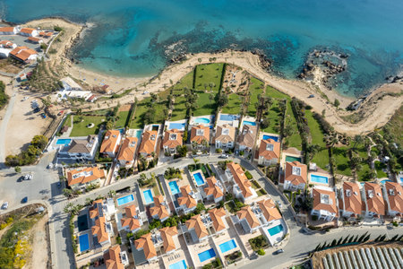 Drone aerial of holiday village with luxury houses at an idyllic rocky coast. Summer vacations at the sea.の写真素材