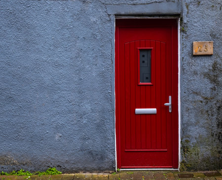 Traditional british house facade front entrance with red closed door. Traditional housesの写真素材