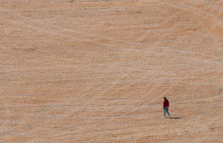 Young woman walking outdoors on in a field. Hiking outdoor. Healthy lifestyle